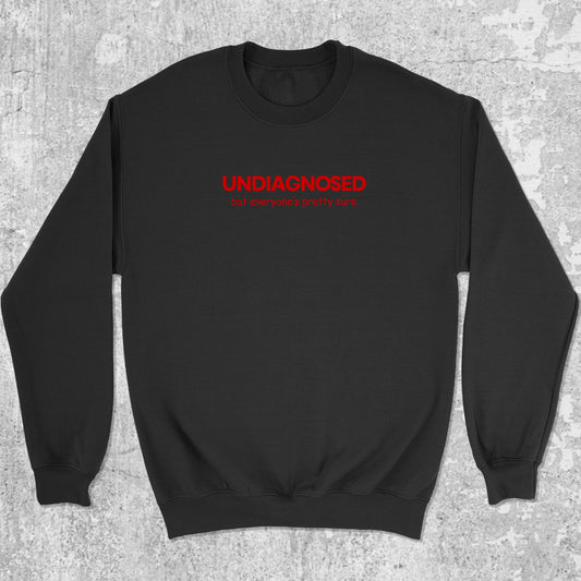Black sweatshirt with red text 'undiagnosed my awesome isn't pretty' on a gray textured background