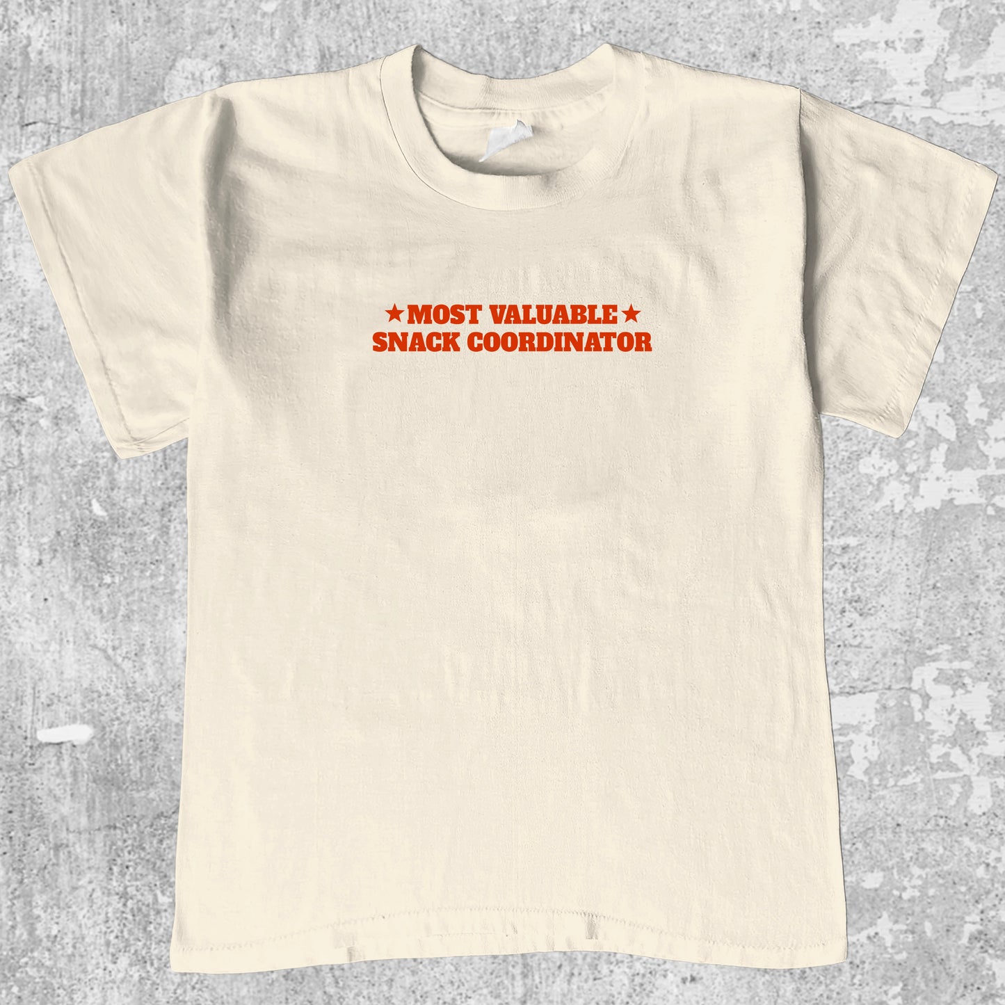Most valuable snack coordinator graphic tee with bold and humorous print, funny and trendy graphic. Perfect for adults and gift-giving. Cream shirt.