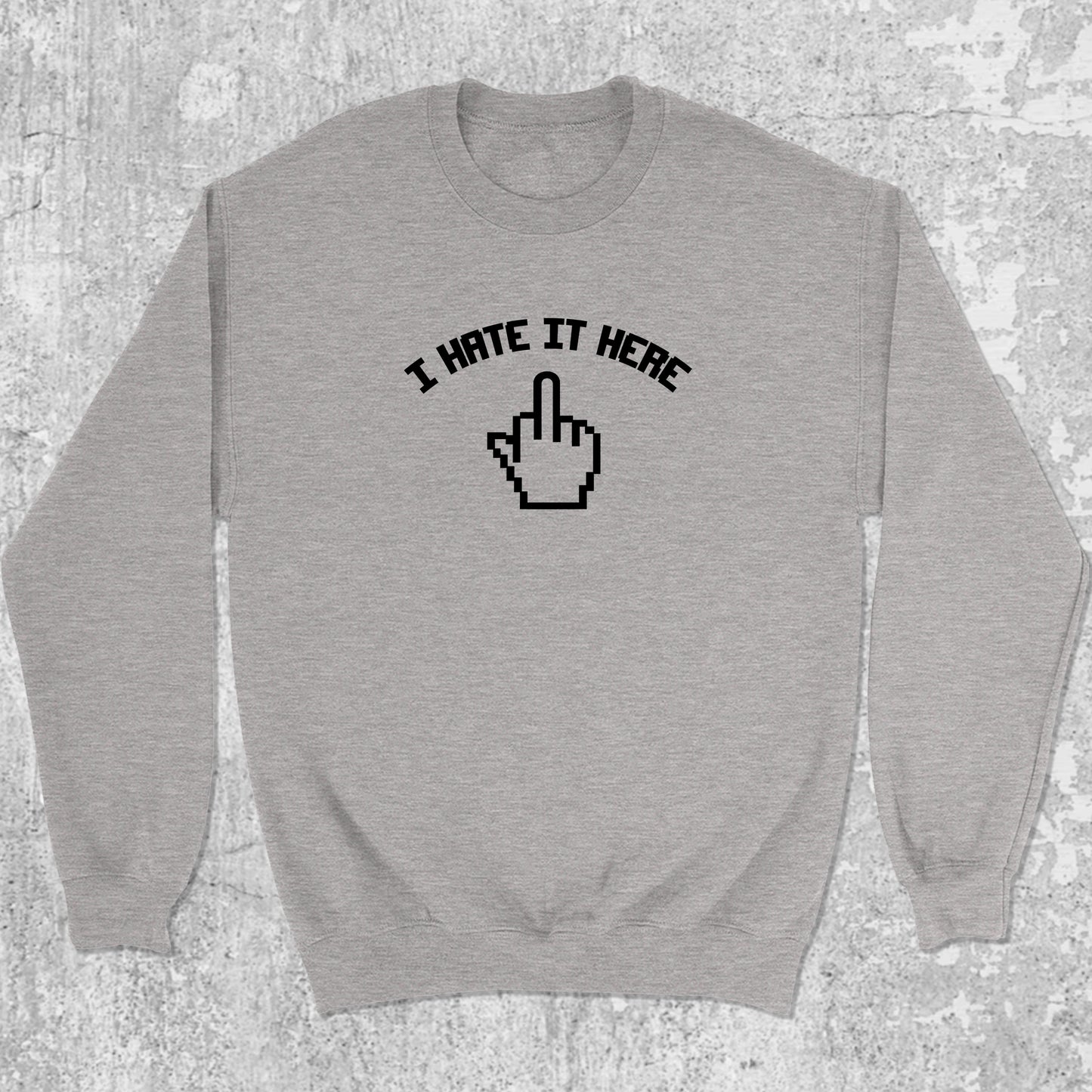 I Hate It Here graphic sweatshirt with bold and humorous print, warm and cozy graphic for everyday wear. Perfect for adults and gift-giving. Heather Grey pullover.