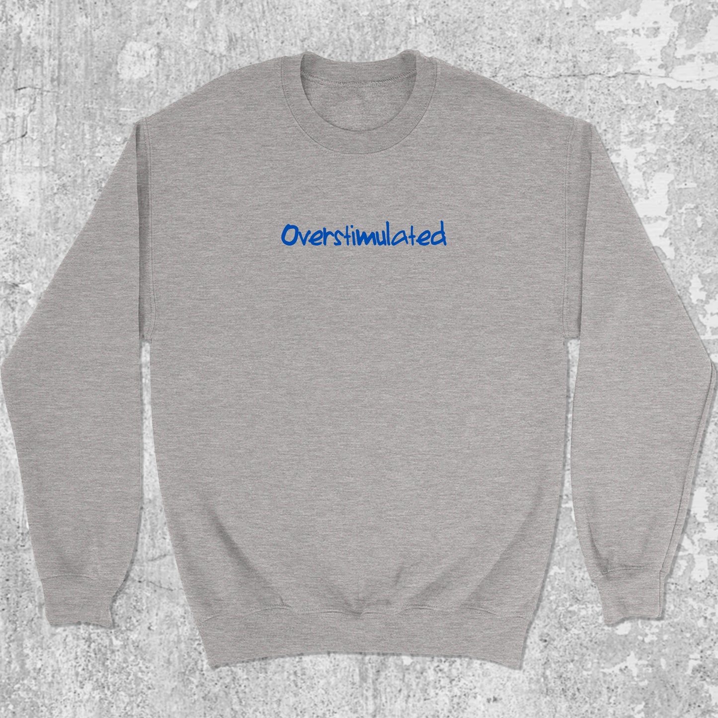 Overstimulated graphic sweatshirt with bold and humorous print, warm and cozy graphic for everyday wear. Perfect gifts for friends and family. Heather Grey pullover.