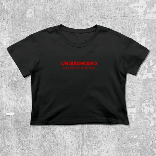 Black t-shirt with red text 'UNDIAGNOSED' on a gray concrete background