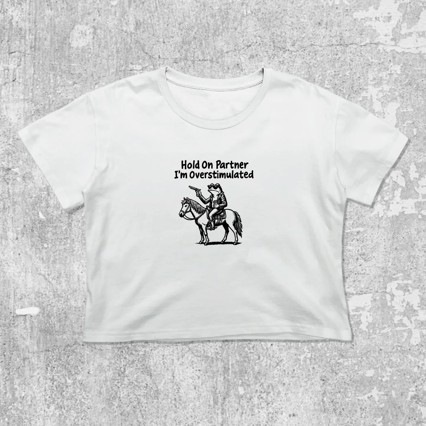Hold On Partner I'm Overstimulated graphic crop tee with cute and trendy fit, featuring playful vintage graphic, stylish cut. White crop t-shirt