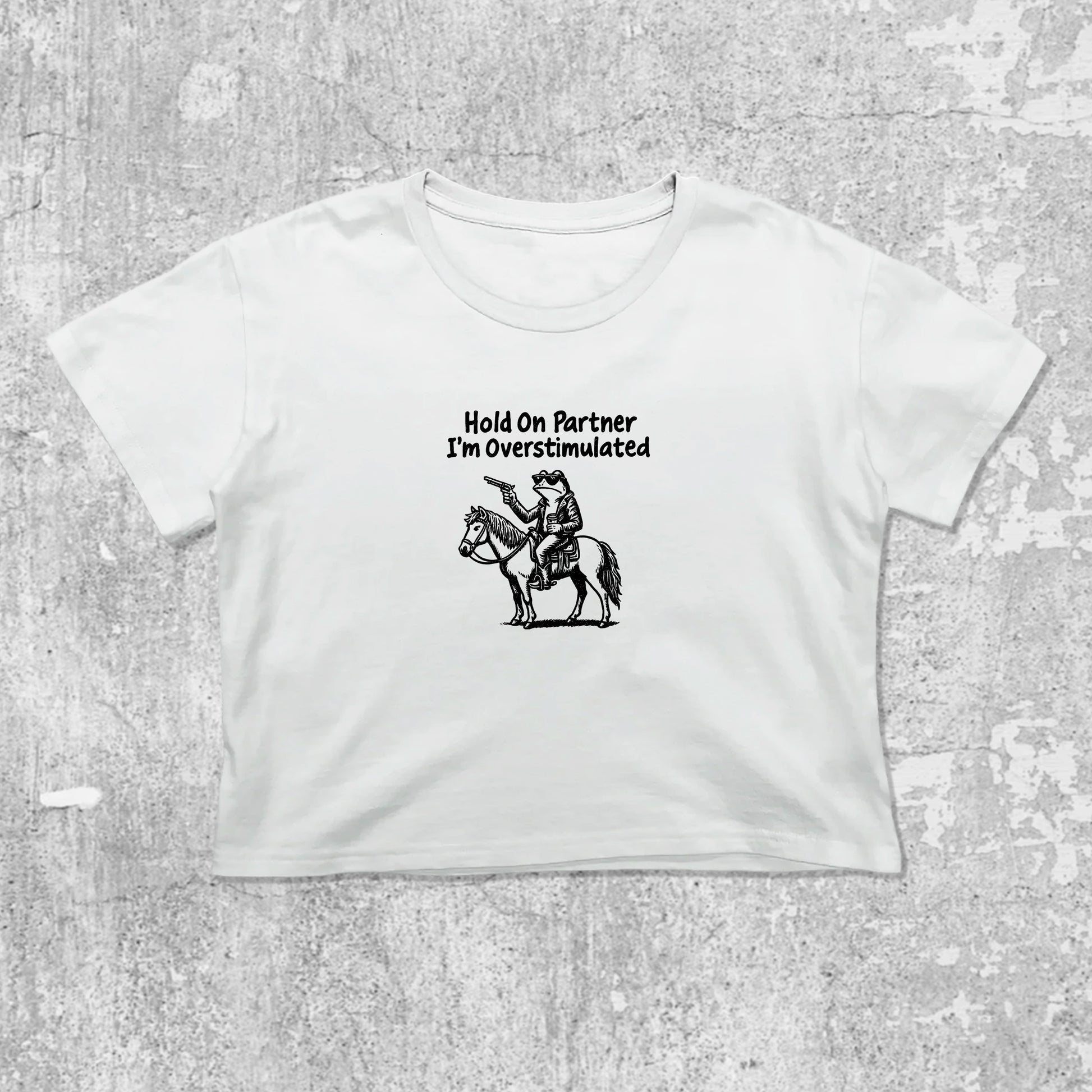 Hold On Partner I'm Overstimulated graphic crop tee with cute and trendy fit, featuring playful vintage graphic, stylish cut. White crop t-shirt