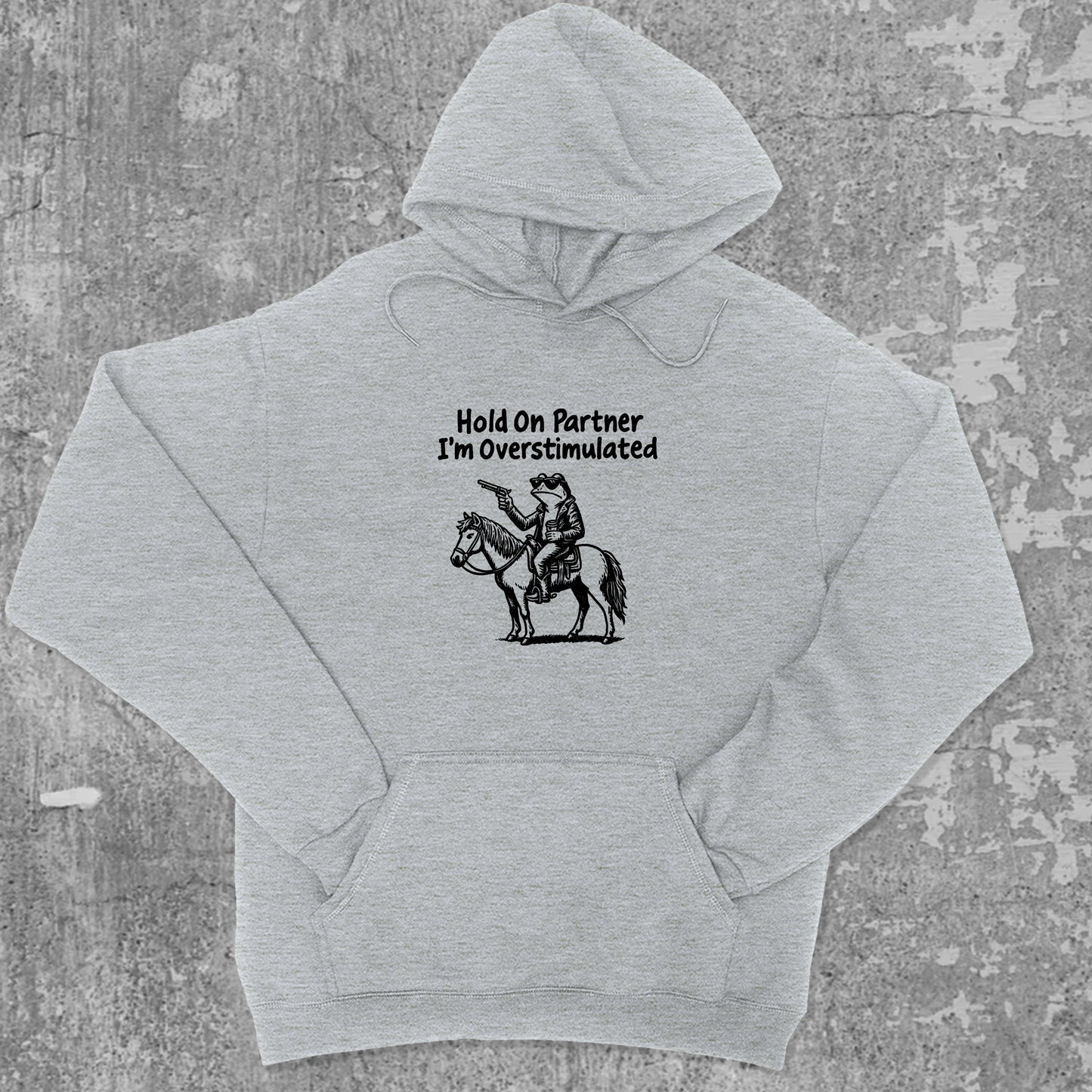Hold On Partner I'm Overstimulated graphic hoodie with funny and simple artwork, casual streetwear with bold personality. Great for adults and gifting. Heather Grey hoodie.