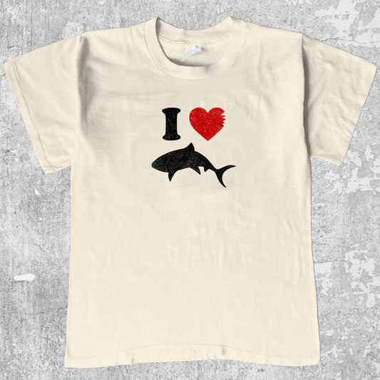 Love Sharks graphic tee with bold and humorous print, funny and trendy graphic. Perfect for adults and gift-giving. Cream shirt.