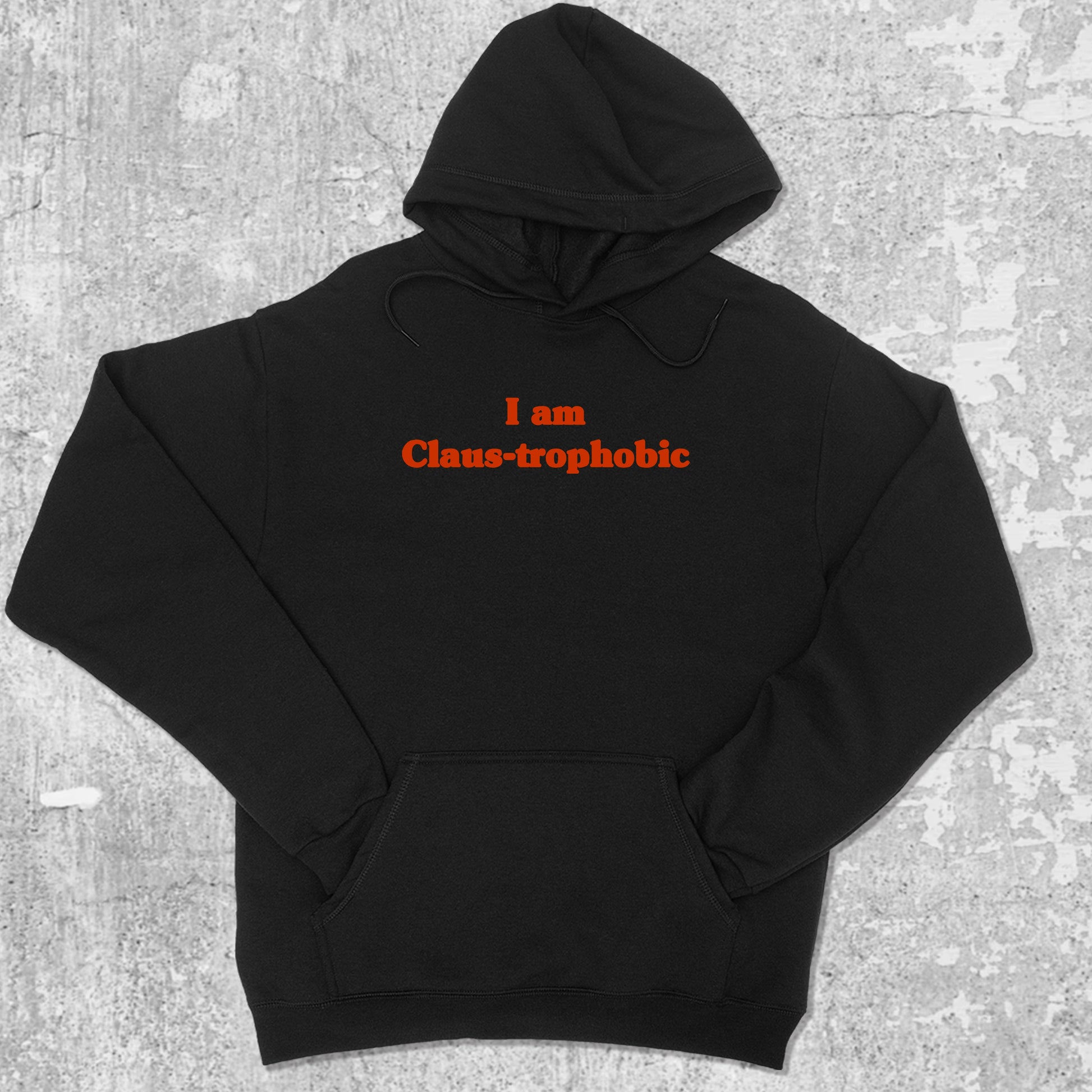 I'm Claus-trophobic graphic hoodie with funny and trendy artwork, casual streetwear with bold personality. Great for adults and gifting. Black hoodie.