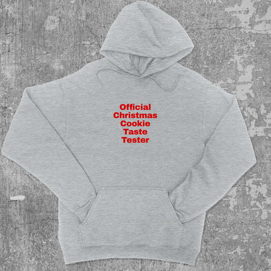 Official Christmas Cookie Taste Tester graphic hoodie with funny and trendy artwork, casual streetwear with bold personality. Great for adults and gifting. Heather Grey hoodie.