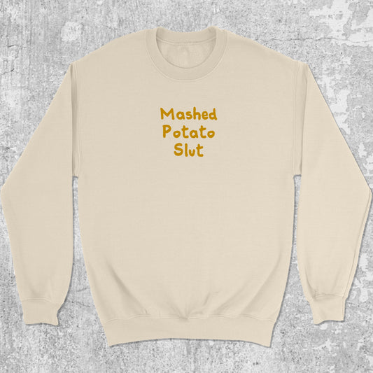 Mashed Potato Slut graphic sweatshirt with bold and humorous print, warm and cozy graphic for everyday wear. Perfect for Christmas gifts for friends and family. Natural pullover.