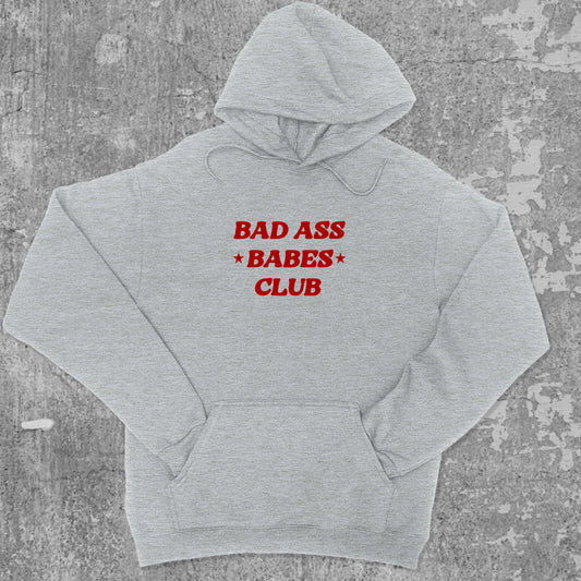 Bad Ass Babes Club graphic hoodie with funny and trendy artwork, casual streetwear with bold personality. Great for adults and gifting. Heather Grey hoodie.