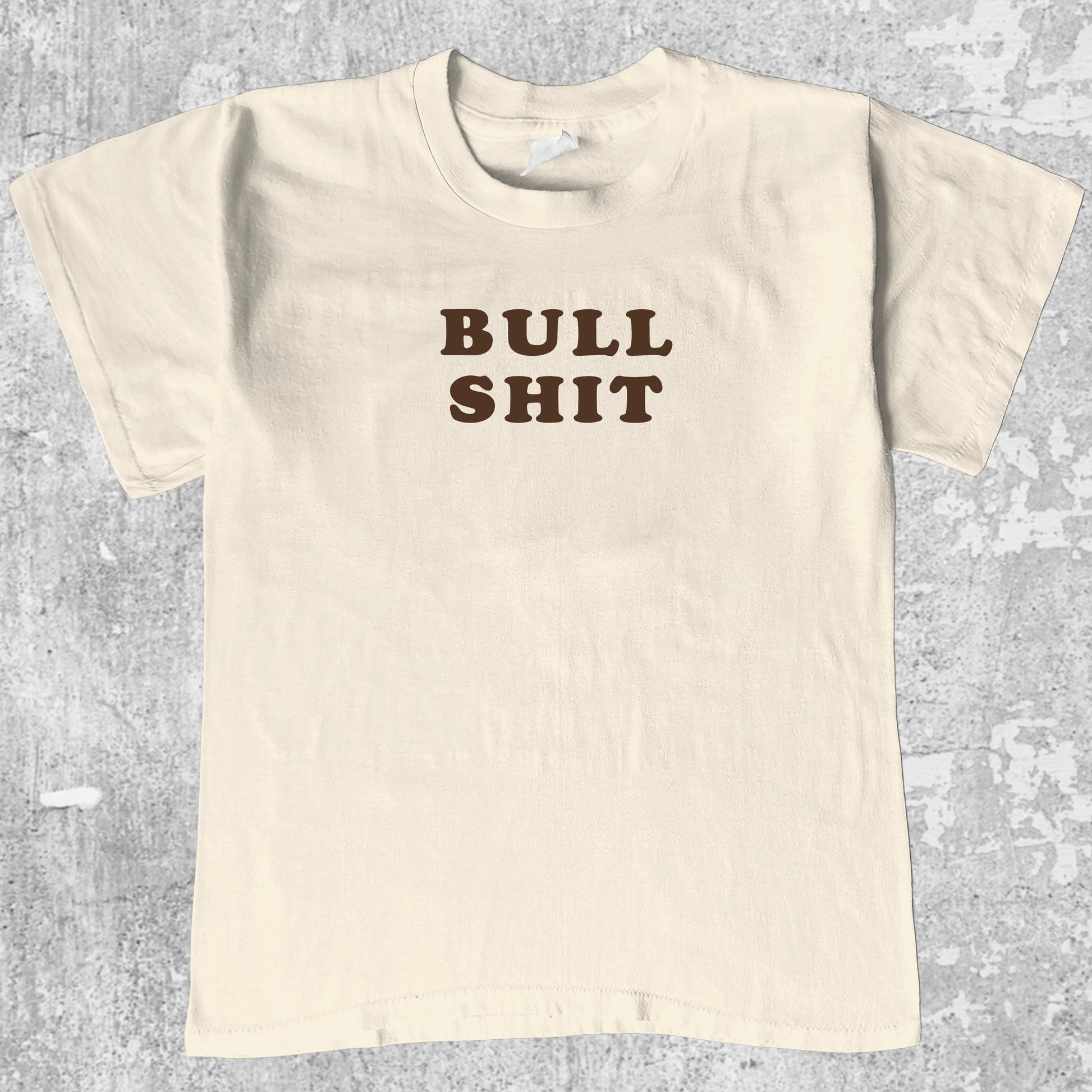 Bull Shit graphic tee with bold and humorous print, funny and trendy graphic. Perfect for adults and gift-giving. Cream shirt.