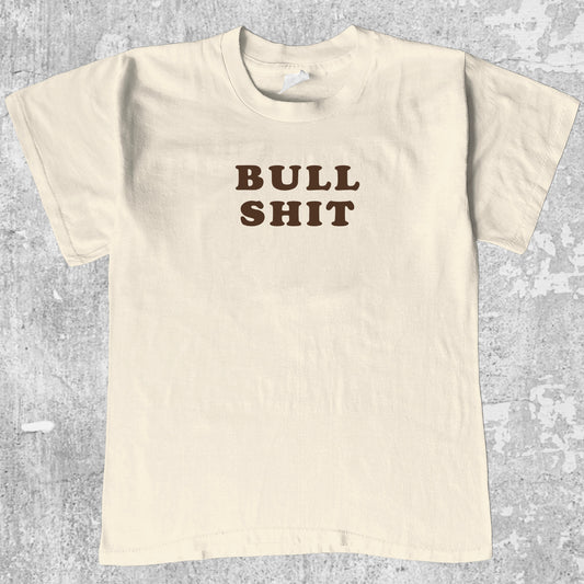Bull Shit graphic tee with bold and humorous print, funny and trendy graphic. Perfect for adults and gift-giving. Cream shirt.