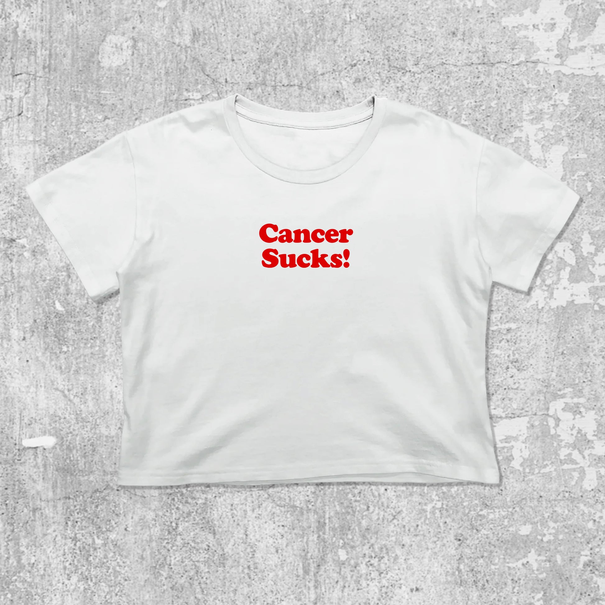 Cancer Sucks graphic crop tee with cute and trendy fit, featuring playful vintage graphic, stylish cut. White crop t-shirt