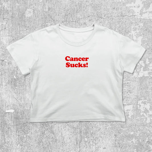 Cancer Sucks graphic crop tee with cute and trendy fit, featuring playful vintage graphic, stylish cut. White crop t-shirt
