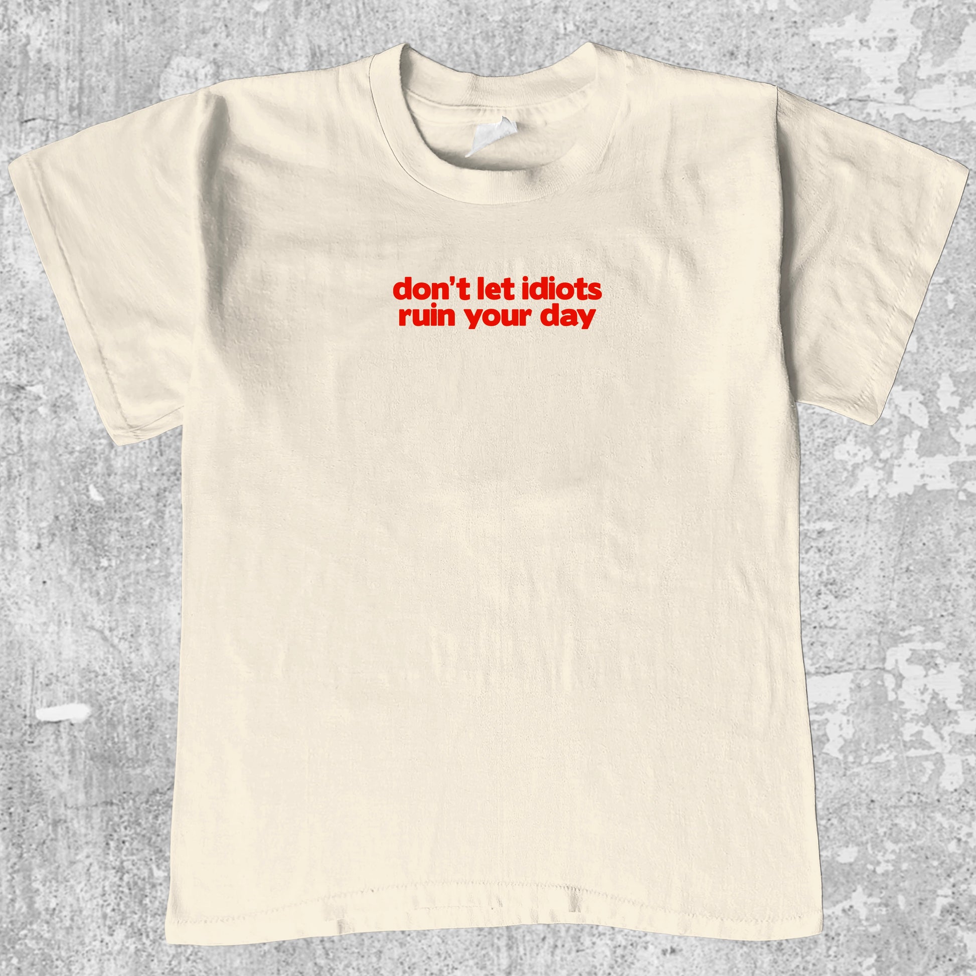 don't let idiots ruin your day graphic tee with bold and humorous print, funny and trendy graphic. Perfect for adults and gift-giving. Cream shirt.
