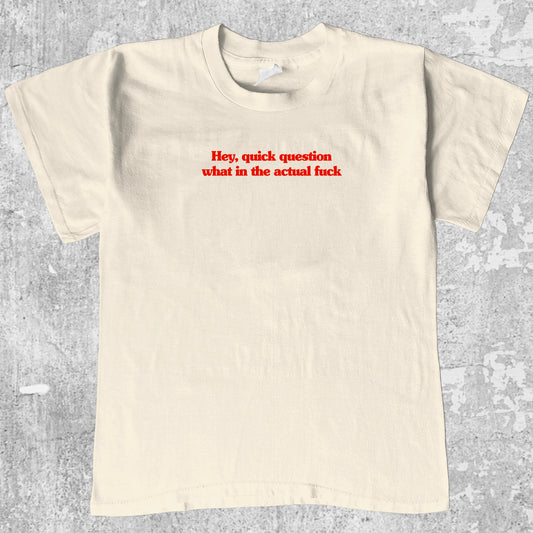 Hey quick question what in the actual fuck graphic tee with bold and humorous print, funny and trendy graphic. Perfect for adults and gift-giving. Cream shirt.