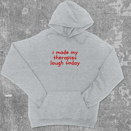 I Made My Therapist Laugh Today graphic hoodie with funny and trendy artwork, casual streetwear with bold personality. Great for adults and gifting. Heather Grey hoodie.