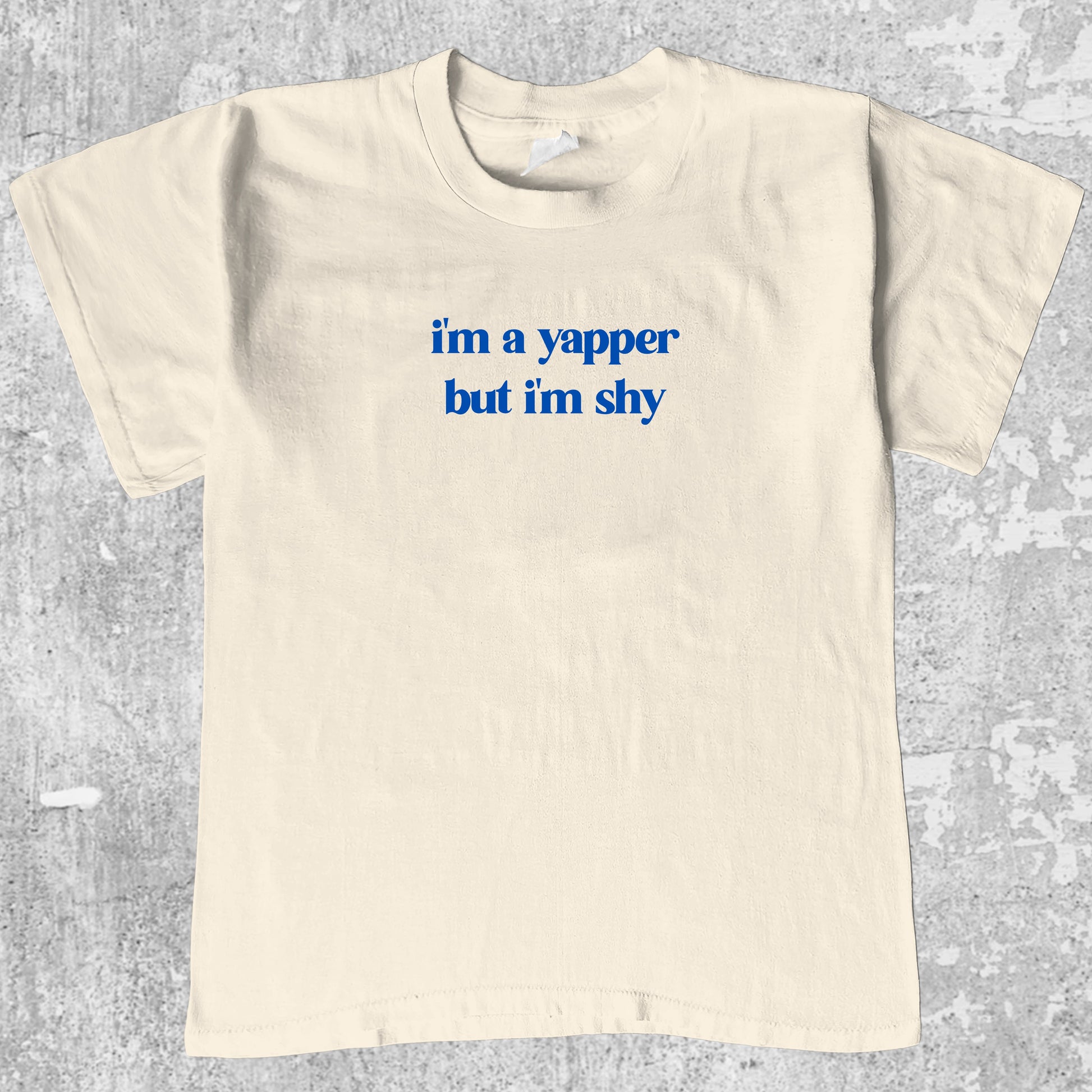 I'm A Yapper But I'm Shy graphic tee with bold and humorous print, funny and trendy graphic. Perfect gifts for friends and family. Cream shirt.