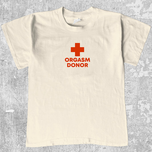 Orgasm Donor graphic tee with bold and humorous print, funny and trendy graphic. Perfect for adults and gift-giving. Cream shirt.