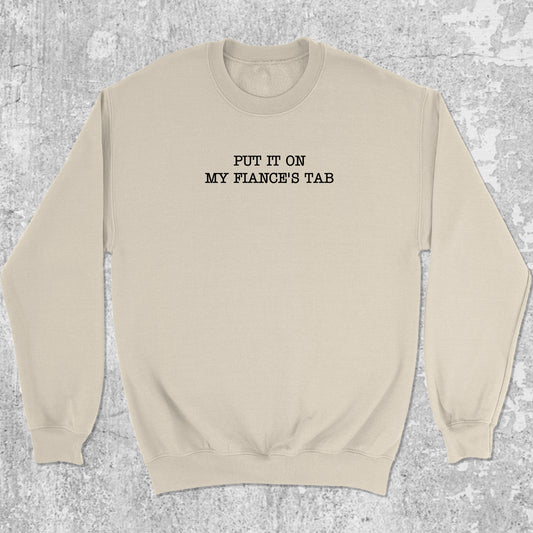 Put It On My Fiance's Tab graphic sweatshirt with bold and humorous print, warm and cozy graphic for everyday wear. Perfect for adults and gift-giving. Natural pullover.
