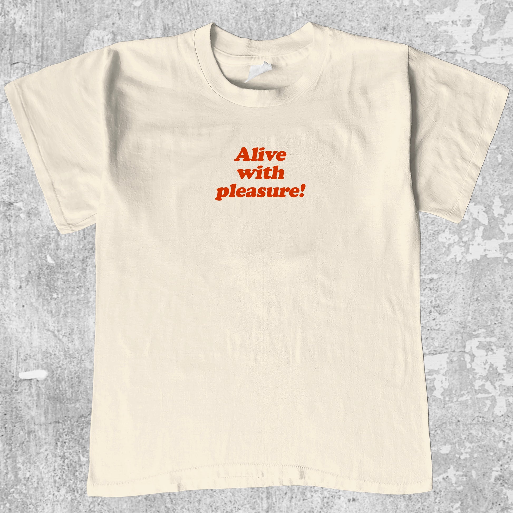 Alive With Pleasure graphic tee with bold and humorous print, funny and trendy graphic. Perfect for adults and gift-giving. Cream shirt.