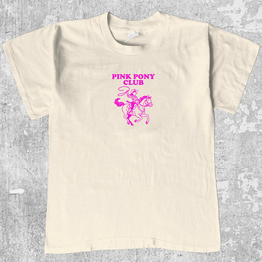 Pink Pony Club graphic tee with bold and humorous print, funny and trendy graphic. Perfect for adults and gift-giving. Cream shirt.