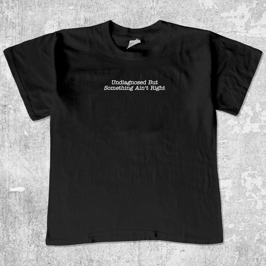 Undiagnosed But Something Ain't Right unisex graphic t-shirt. Vintage trending meme tee. Funny and unique graphic tees. Undiagnosed But Something Ain't Right graphi tee Black 1